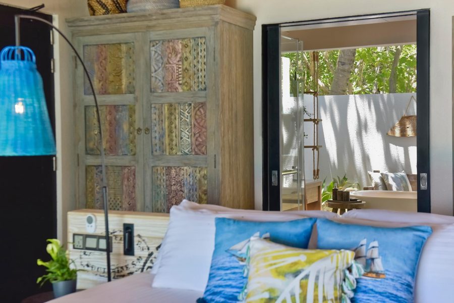 Grand Park Maldives — villa bedroom with carved armoire